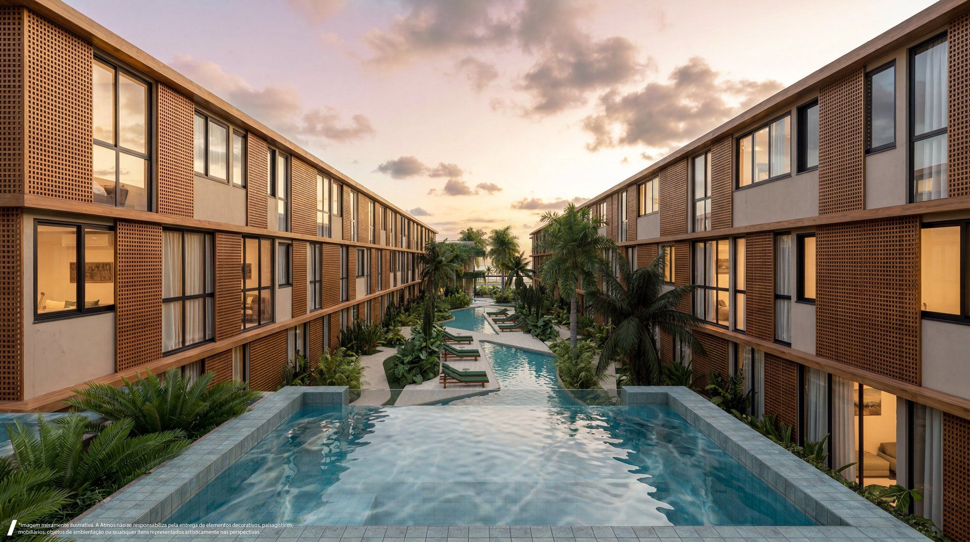 Piscina linear com deck e paisagismo tropical entre os blocos do empreendimento