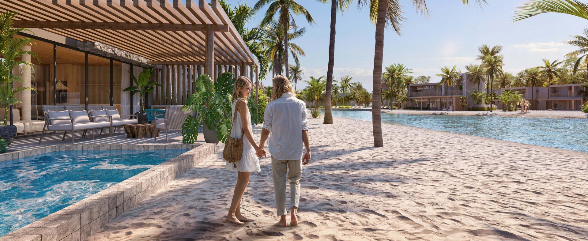 Casal caminha pela orla de água doce entre as casas e o beach club