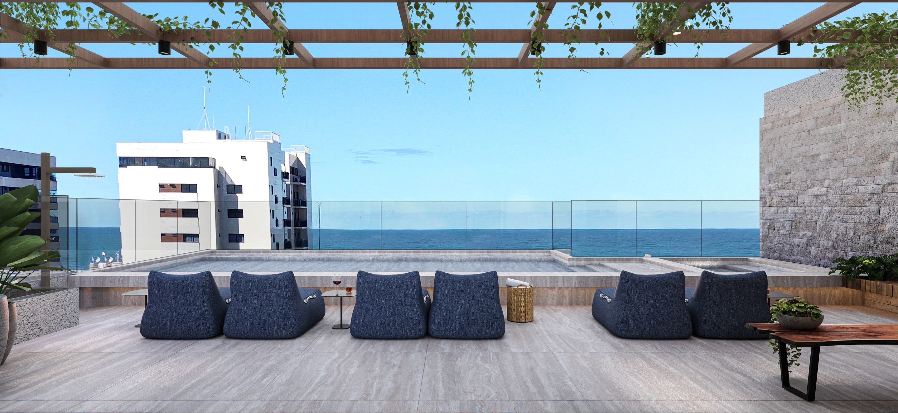 Piscina no rooftop com área de descanso e vista para o mar