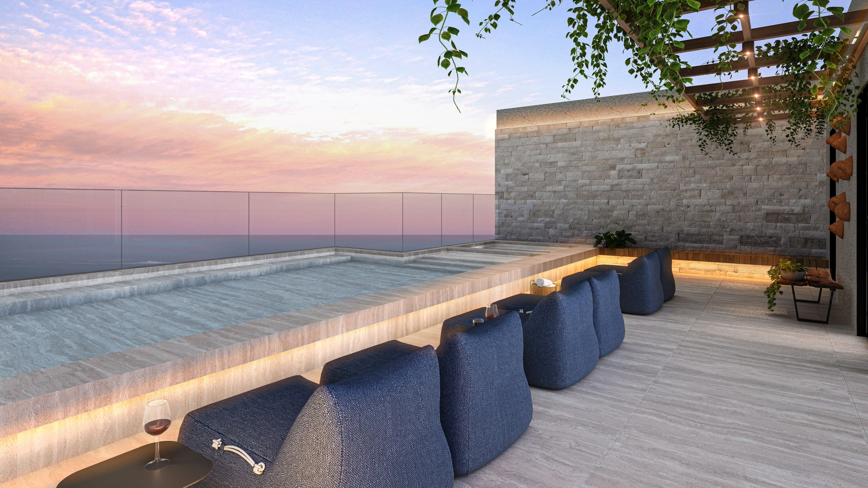 Área de lazer no rooftop ao entardecer com piscina e vista para o oceano