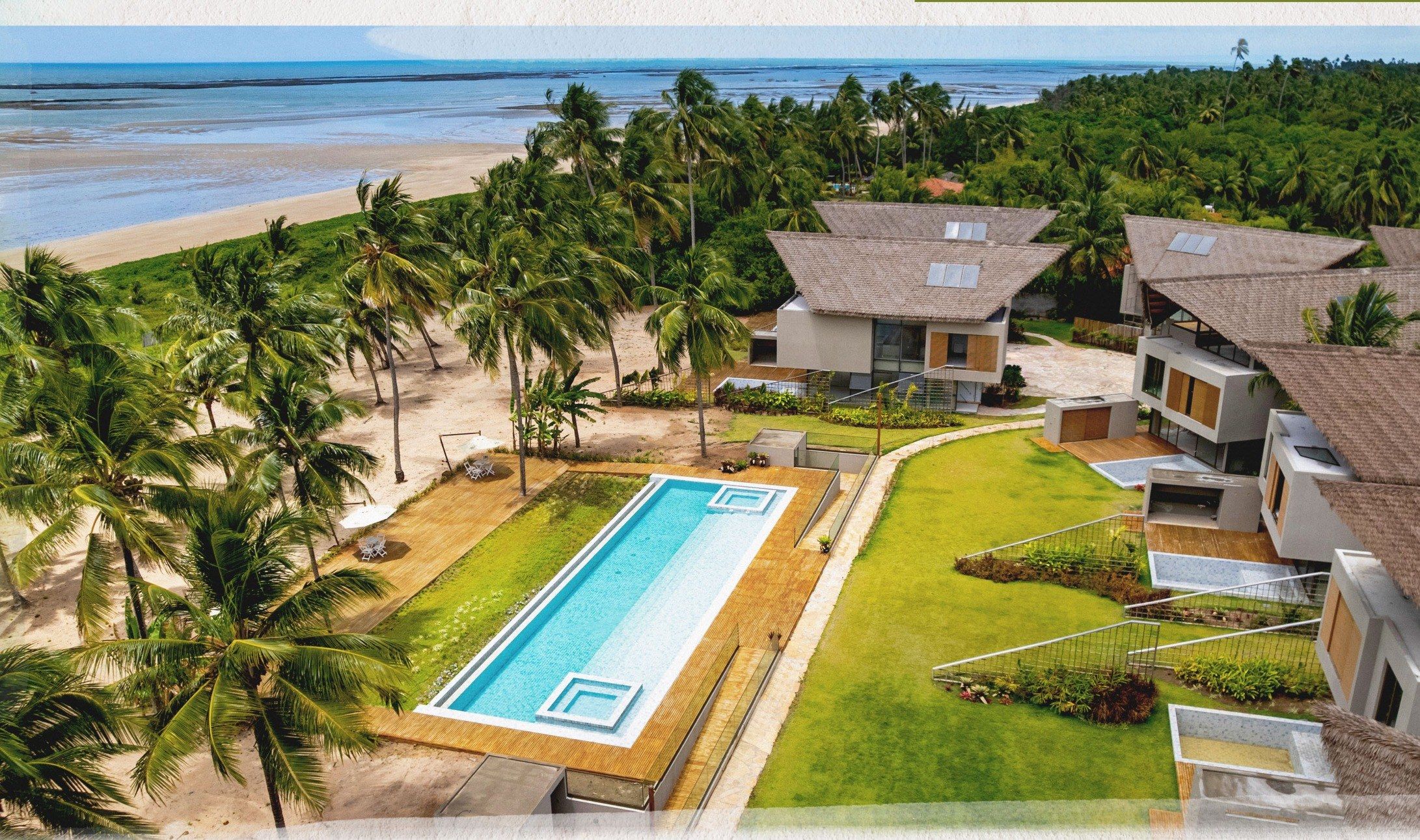 Vista aérea da área comum, com a piscina adulto e a praia ao fundo (foto de outubro de 2025)